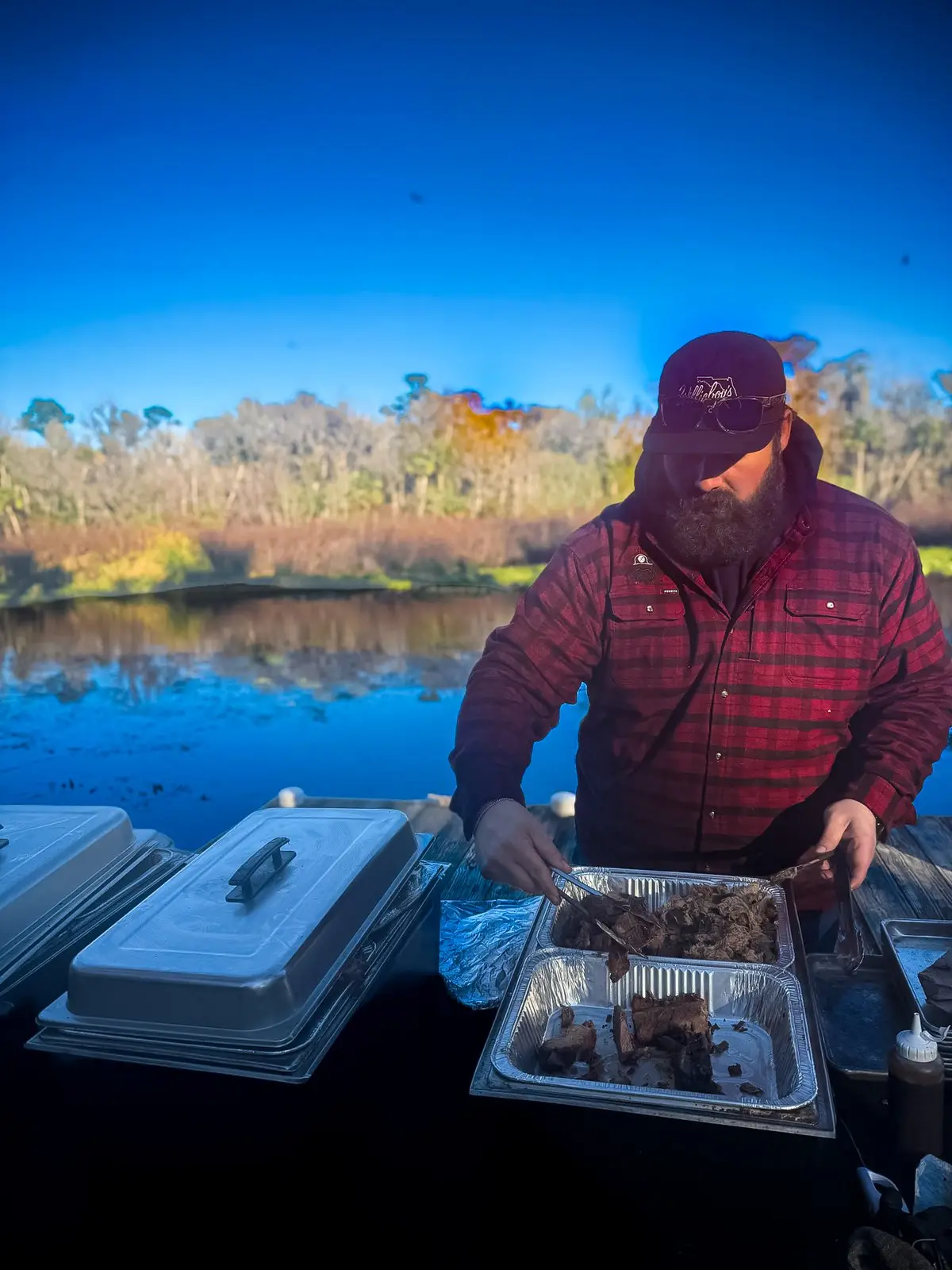 Willieboy's BBQ pitmaster serving smoked brisket at a lakeside catering event
