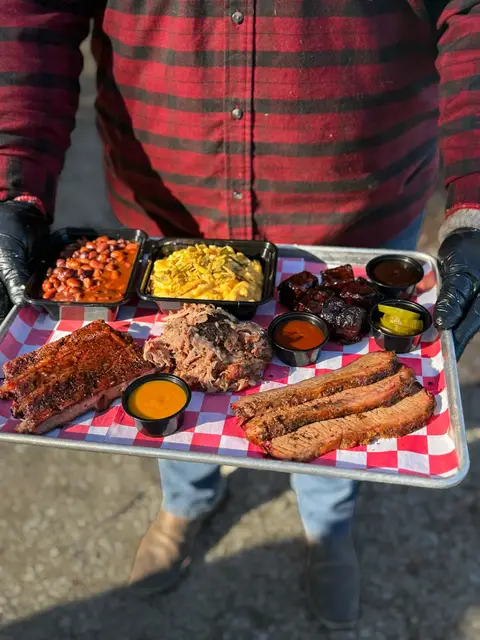 BBQ sampler tray with ribs, brisket, pulled pork, burnt ends, and sides