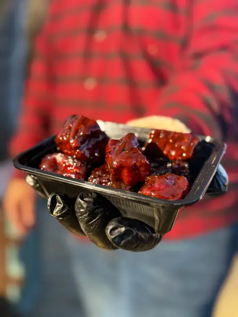 Glazed pork belly burnt ends in a takeout container
